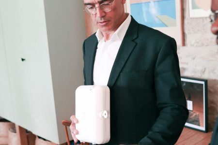 Homme en costume tenant un diffuseur Indifair pendant une démonstration technique, illustrant l’expertise produit.