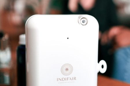 Diffuseur blanc Indifair posé sur une table en bois, prêt à parfumer un espace avec élégance et précision.